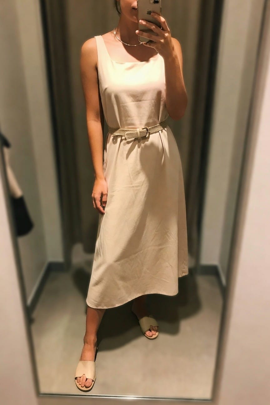 Woman in a sleeveless cream midi dress with square neckline and woven belt, paired with matching slide sandals, shown in a mirror selfie.