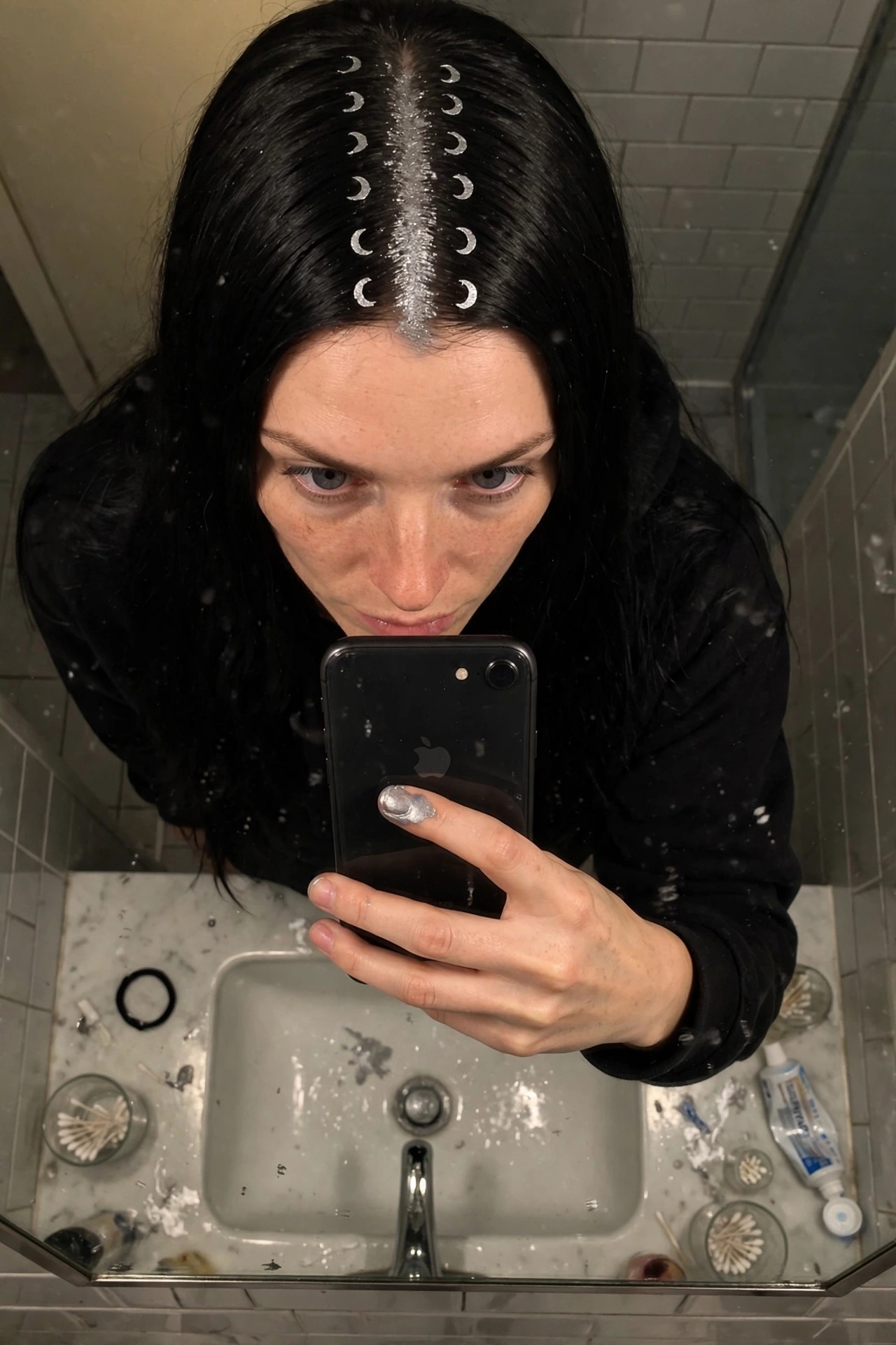 Long straight black hair with a center part filled with silver glitter and small white crescent moons placed symmetrically along both sides of the part.