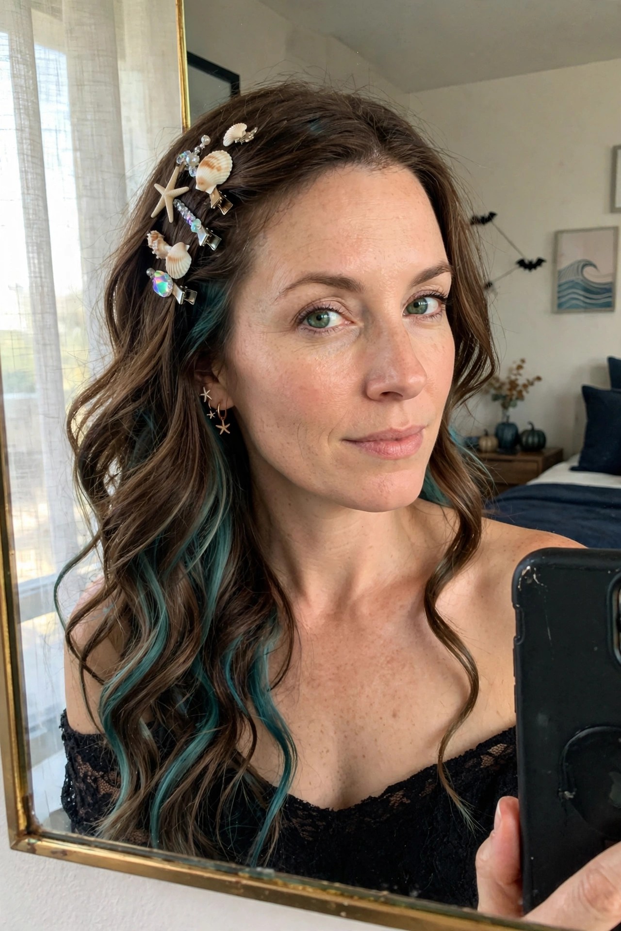 Woman with long wavy brown hair featuring teal streaks, styled with multiple seashell, starfish, and pearl hair clips clustered along one side.