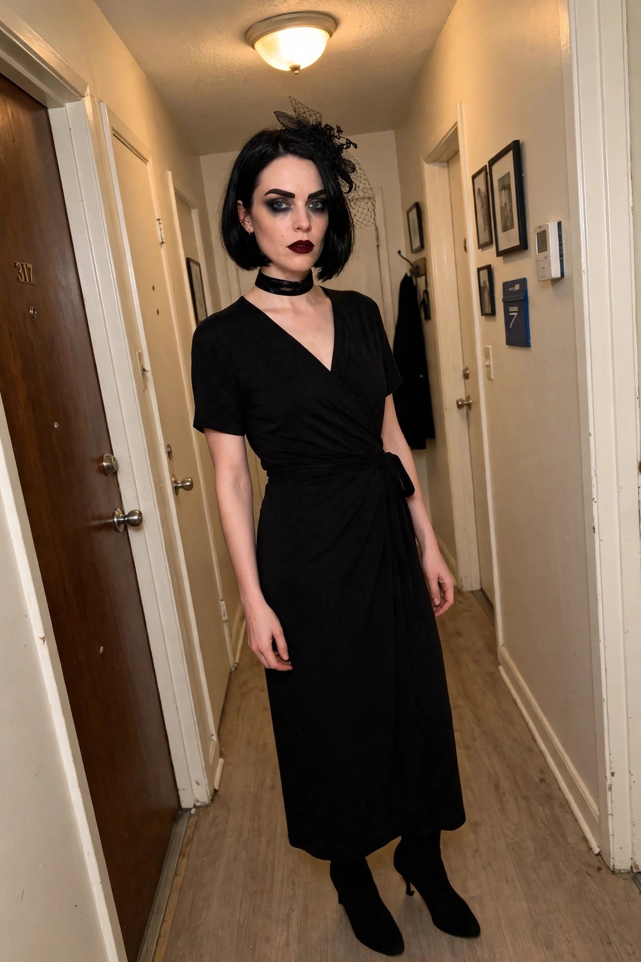 Woman wearing a black wrap dress with a small black veil fascinator, choker, and dark eye makeup as a gothic widow Halloween costume.