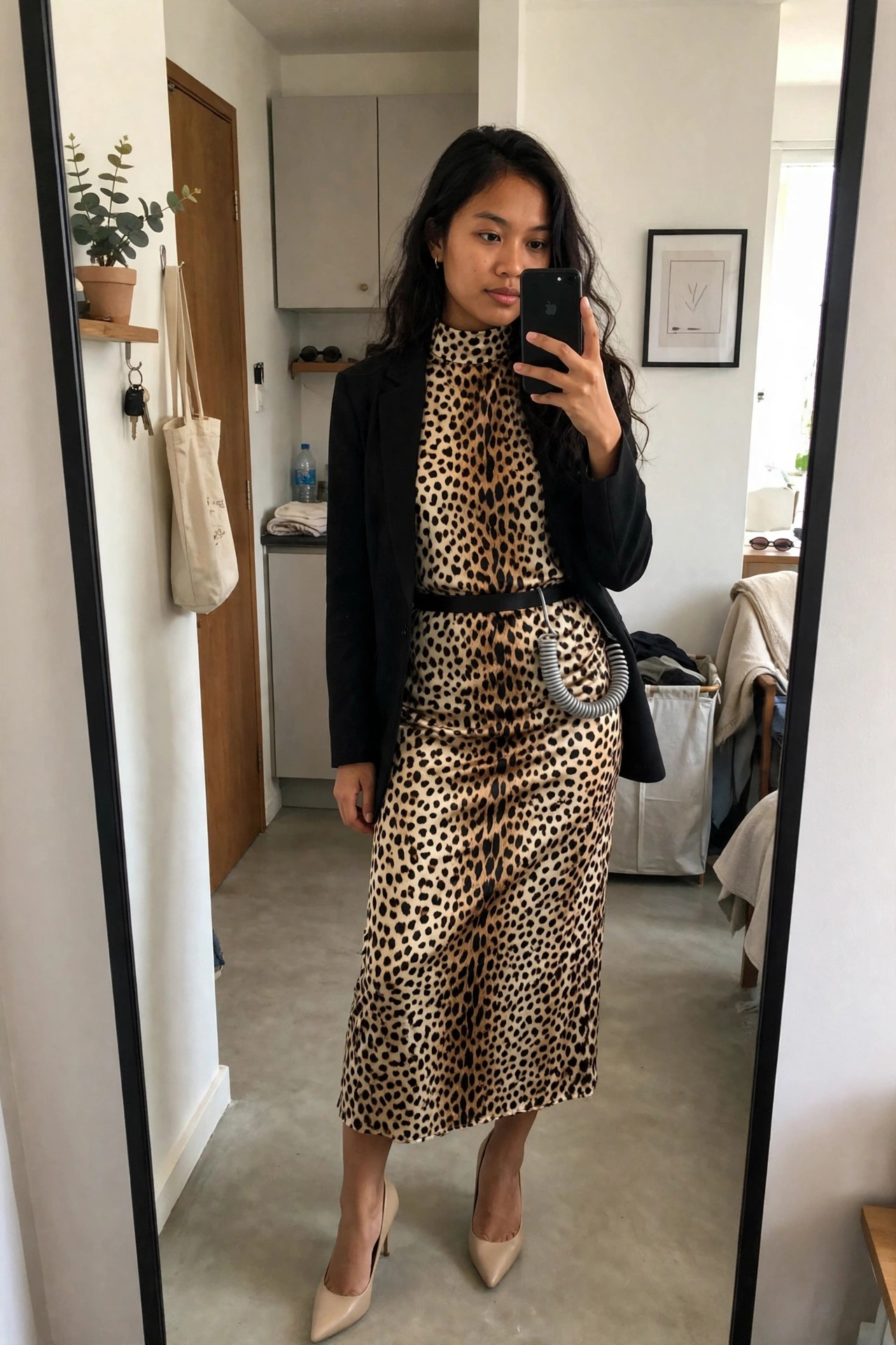 Woman wearing a leopard print high neck top and matching midi skirt with a black blazer as a cheetah costume.
