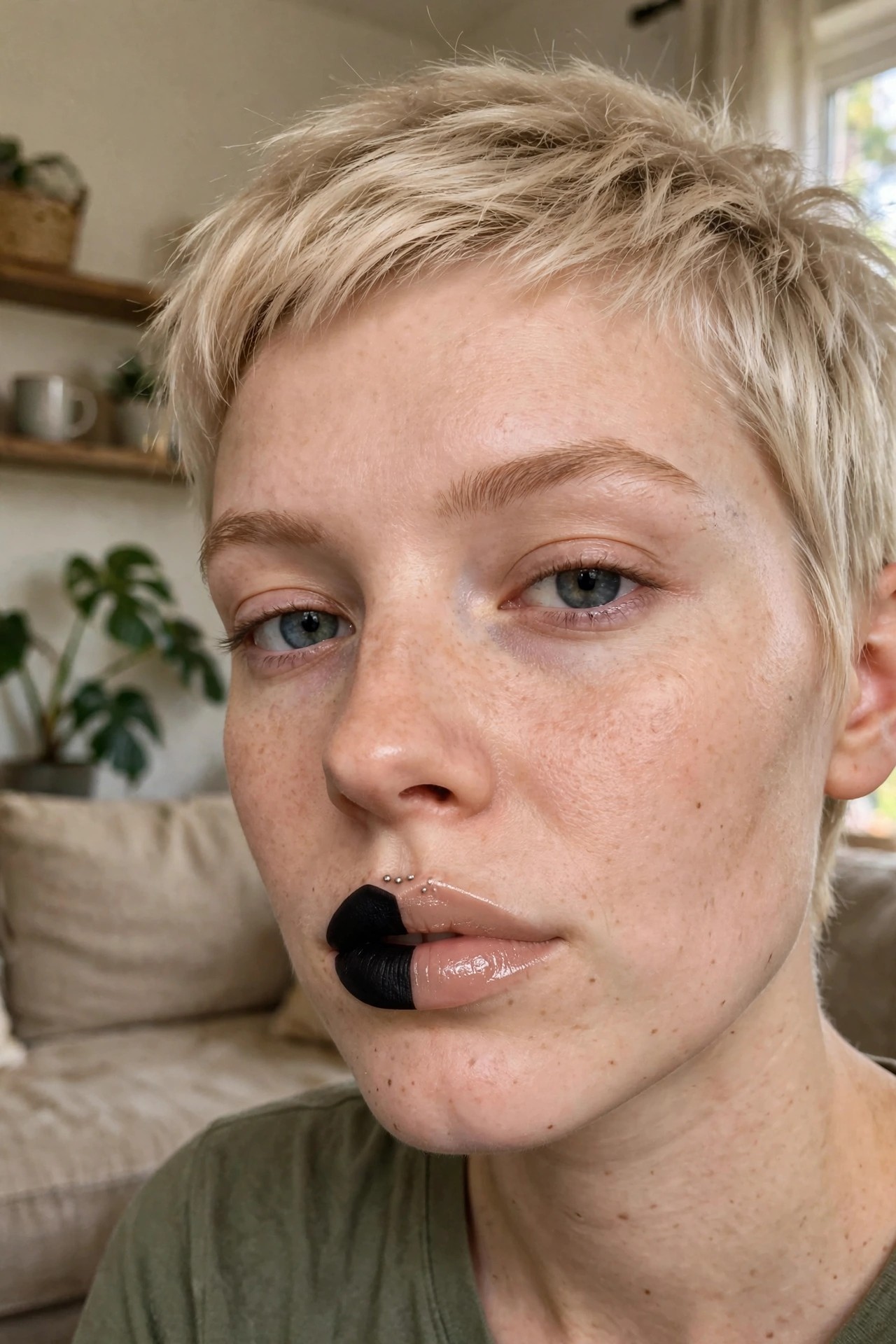 Close up of split lip makeup with black on the left side and nude gloss on the right side of the lips.
